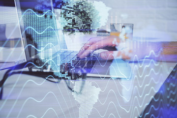 Multi exposure of graph with man typing on computer in office on background. Concept of hard work. Closeup.