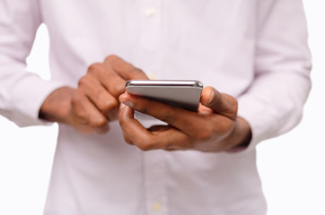 Black man using smartphone, browsing social media over white background