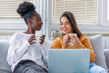 Portrait of funny and happy young women watching comedy in bed and laughing. Cheerful friends...