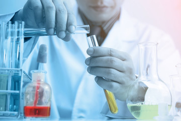 Fototapeta premium Scientist testing some chemical sample at laboratory with lab glassware on the table. Science research and development new innovation technology concept.