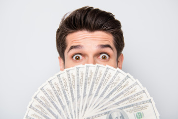 Close up cropped photo of crazy excited man hiding behind fan of money staring into camera not...