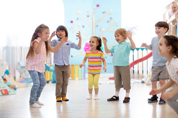 Group of happy children jumping in club. Kids playing together