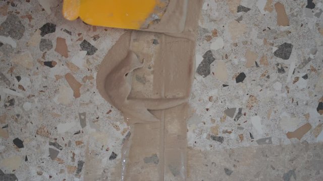 Repair and decoration of apartments and houses. woman fugues seams tiles in the bathroom