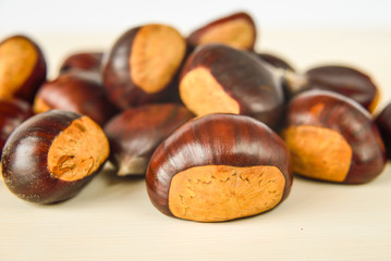 Castagne mature appena raccolte su tagliere bianco