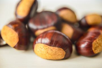 Castagne mature appena raccolte su tagliere bianco