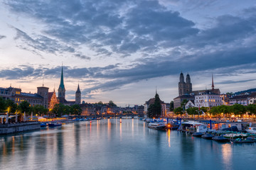 Zurich downtown skyline with Fraumunster and Grossmunster churches at lake zurich at night,...