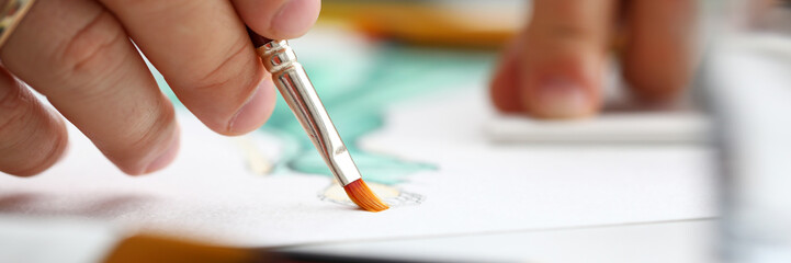 Male hand making drawing with watercolor brush