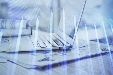 Stock market graph on background with desk and personal computer. Double exposure. Concept of financial analysis.