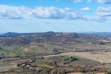 Obraz premium Picturesque winter landscape view of Tuscany with stone houses, colorful hills, fields and vineyards in Italy.
