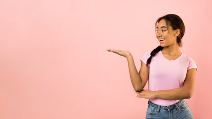 Happy girl showing something on her empty palm, free space