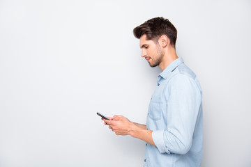Profile side photo of concentrated man at copyspace using his cellphone reading feednews in social...