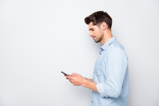 Profile side photo of concentrated man at copyspace using his cellphone reading feednews in social network accounts typing posts wear style outfit isolated over grey color background