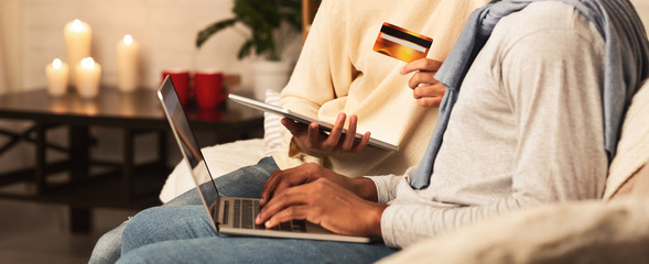 Online shopping. Afro couple using laptop and credit card
