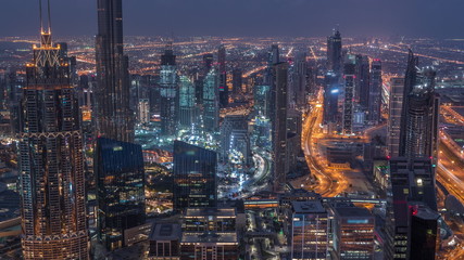 Dubai Downtown skyline futuristic cityscape with many skyscrapers and Burj Khalifa aerial night to day timelapse.