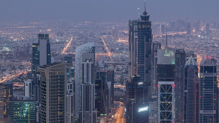 Obraz premium Dubai Downtown skyline futuristic cityscape with many skyscrapers and Burj Khalifa aerial night to day timelapse.