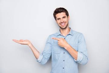 Portrait of positive cheerful promoter man hold hand point index finger indicate information about...