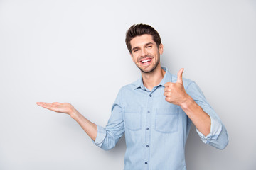 Portrait of positive cheerful man hold hand show thumb-up sign recommend ads display promo wear...