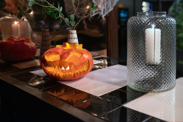 A pumpkin in the form of a smiling face is standing on the bar on the eve of the helloween holiday