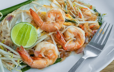 Close-up Pad Thai, Thai traditional food, or rice noodles with fresh shrimps and vegetables. Front view