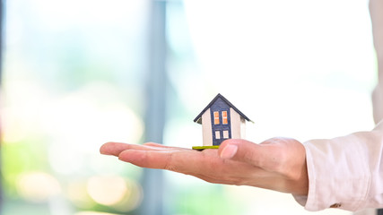 Side view a house model in a hands.