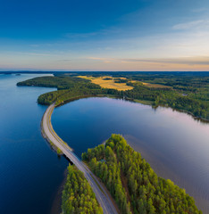 Luftaufnahme von Pulkkilanharju Ridge, Paijanne National Park, südlicher Teil des Lake Paijanne. Landschaft mit Drohne. Blaue Seen, Felder und grüne Wälder von oben an einem Sommertag bei Sonnenuntergang in Finnland.