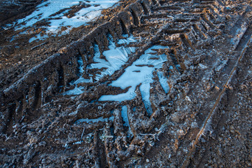 Frozen puddles on mud farm track