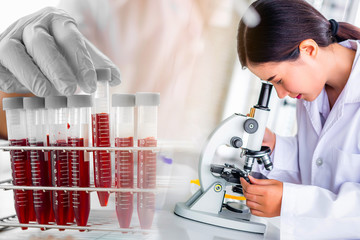Attractive scientist woman lab technician assistant analyzing a blood sample in test tube at laboratory. Medical, pharmaceutical and scientific research and development concept.