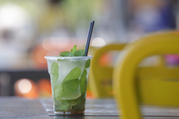 Mojito cocktail in a plastic glass in the beach bar, cold summer refreshment