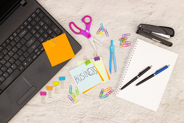 Top view of office table. Office table full with office supplies and motivation note on paper 