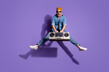 Full length body size photo of screaming cheerful handsome attractive music lover shouting with having won retro recorder wearing jeans jacket brown cap headwear isolated over purple vivid color