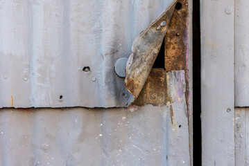 Metallic warehouse door painted grey with gap and rust