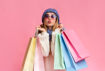 Young girl with shopping bags showing kissing lips
