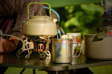 Coffee mugs and cooking utensils for hiking. Survival equipment for camping concept.