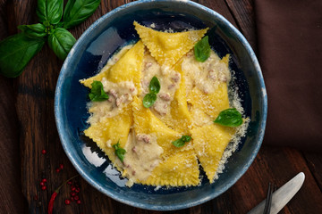 Traditional Italian ravioli stuffed with potatoes and cheese in a creamy Carbonara sauce. Italian cuisine rustic style