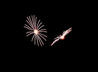 Two small white fireworks exploading in the sky during show