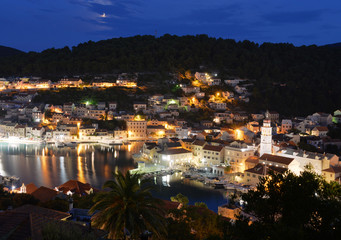 Fototapeta premium Pučišća Insel Brač Kroatien Nachtaufnahme Lichter Mondfinsternis Hafen Panorama Adria Mittelmeer Urlaub Stimmung Yachten Segelboote Fjord Wasserport Illumination mediterran Ferien Aussicht