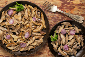 Delicious fried mushrooms in pan on table