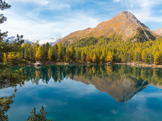 Autumn landscape, forests and alpine lake. Trekking in mountain in autumn season