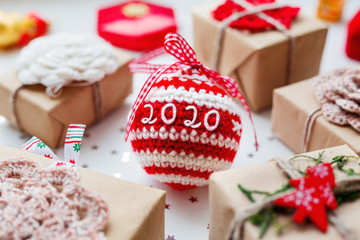 Fototapeta na wymiar Christmas and New Year 2020 background with presents, decorations and crocheted handmade decorative ball.