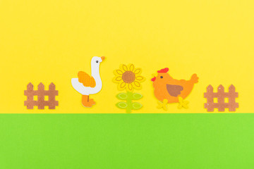Obraz na płótnie Canvas White Duck and chicken Farm animals on a bright green and yellow flat lay background with a fence and flower scene and copy space open. Conceptual.