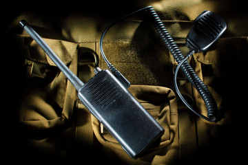 Walkie Talkie and microphone on a tan backback.