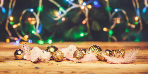 Cute Christmas toys with light pink feathers on wooden table © Golib Tolibov