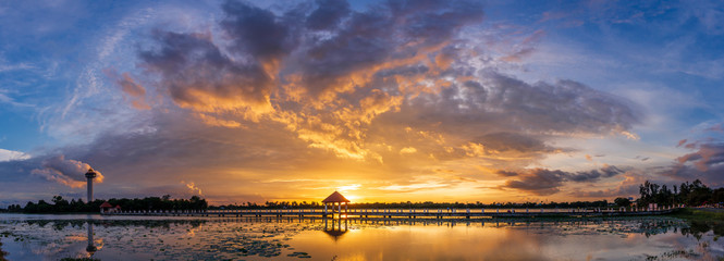 Panorama image. sunset on dark background.Vivid orange cloud sky.