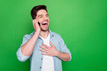 Photo of handsome guy holding telephone hand near ear listen best friend humorous story laughing...