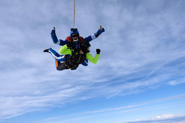 Skydiving. Tandem jump. An instructor and a passenger are flying  in the sky.