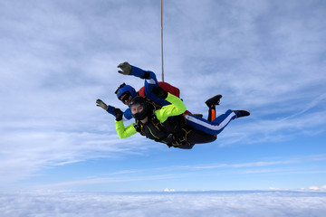 Skydiving. Tandem jump. An instructor and a passenger are flying  in the sky.