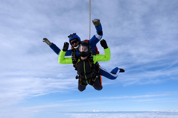 Skydiving. Tandem jump. An instructor and a passenger are flying  in the sky.