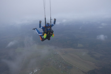 Skydiving. Tandem jump. An instructor and a passenger are flying  in the sky.