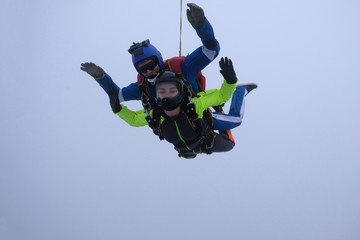 Fototapeta na wymiar Skydiving. Tandem jump. An instructor and a passenger are flying in the sky.