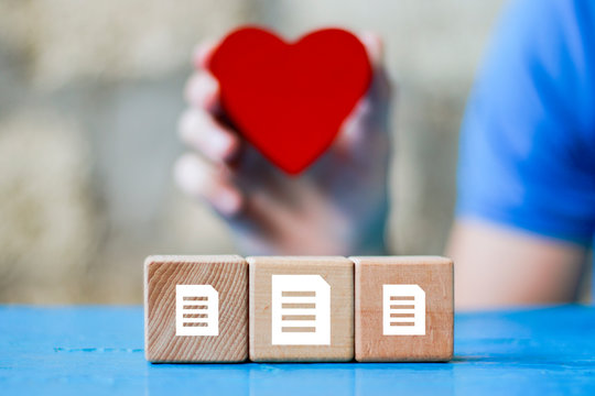 Business file icon on wood block, healthcare service in the background of the heart. - Powered by Adobe